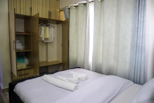 een slaapkamer met een bed met handdoeken erop bij Cosy Flamingo furnished apartments in Nakuru