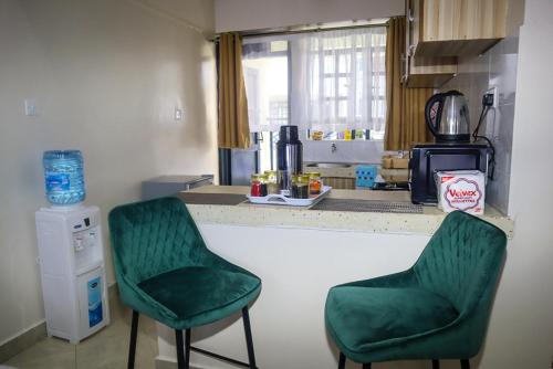 twee groene stoelen naast een aanrecht bij Cosy Flamingo furnished apartments in Nakuru