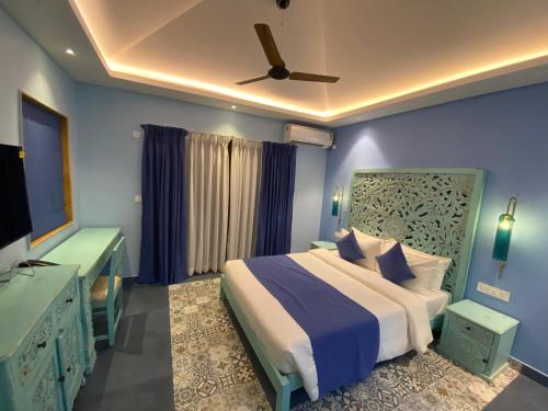 a bedroom with a bed and a ceiling fan at Atmani waterfront resort in Cola