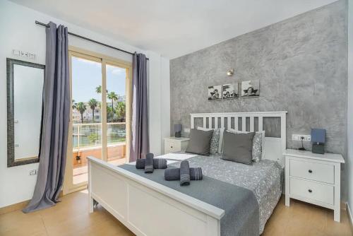 ein Schlafzimmer mit einem großen Bett und einem großen Fenster in der Unterkunft Villa Pyp in Port d'Alcúdia