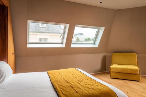 - une chambre avec un lit et une chaise jaune dans l'établissement Chateaudun Opéra, à Paris