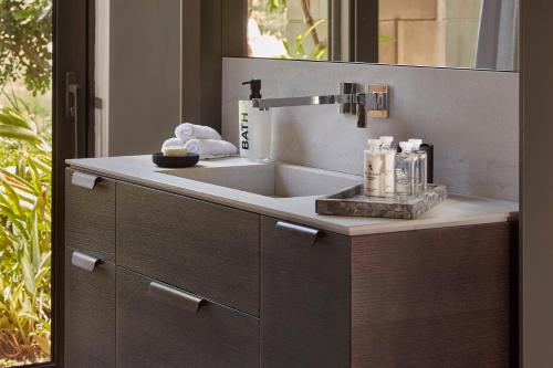 a bathroom with a sink and a mirror at YAMA Resort in Kibbutz Ginnosar