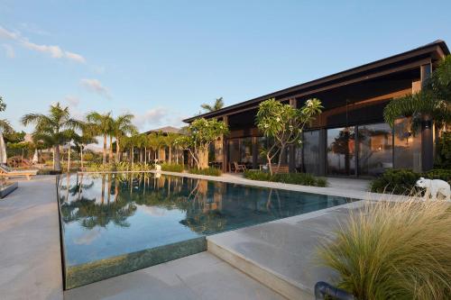 a house with a swimming pool in front of a building at YAMA Resort in Kibbutz Ginnosar