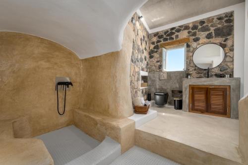 bagno con vasca, lavandino e specchio di Geminos Complex Villas a Kamari