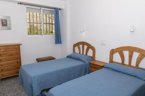 1 dormitorio con 2 camas, vestidor y ventana en Trianon, 5º-29, en Cullera