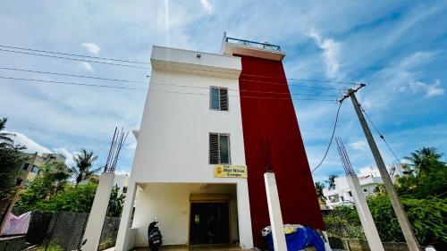 un edificio con una torre roja y blanca en Hotel Star Nivas, Srirangam, en Tiruchchirāppalli