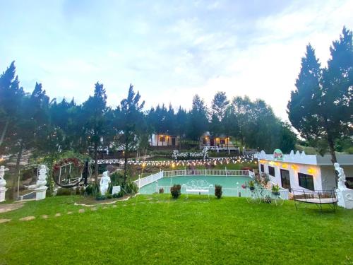 a resort with a swimming pool in a yard at เนริสารีสอร์ท เขาค้อ in Ban Khao Ya Nua