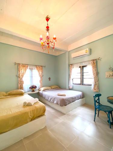 a bedroom with two beds and a chandelier at เนริสารีสอร์ท เขาค้อ in Ban Khao Ya Nua