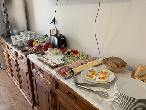 a breakfast buffet with meat and other foods on a counter at Penzion U Kostela in Kuželov