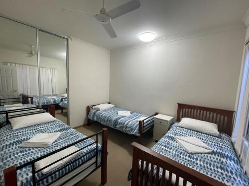 a room with three beds and a mirror at Unit 24 Seafront Estate in Jurien Bay