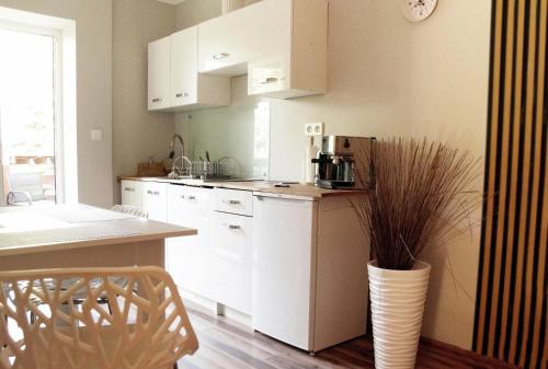 a kitchen with white cabinets and a vase at Apartament Zacisze in Wieliczka