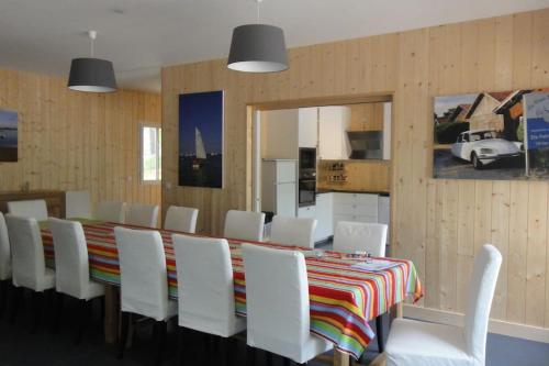 une salle à manger avec une grande table et des chaises blanches dans l'établissement Cap-Ferret -Très grande maison famille- plage 150m, à Lège-Cap-Ferret