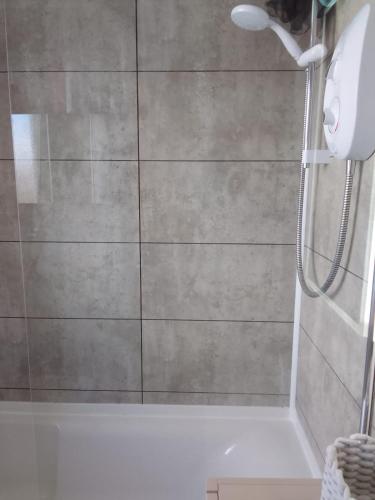 a bathroom with a shower with a glass door at Mide’s House in Invergowrie