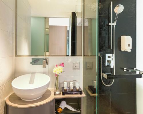 a bathroom with a sink and a shower at Silka Tsuen Wan, Hong Kong in Hong Kong