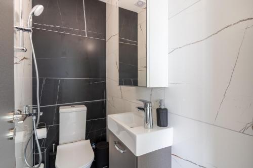 uma casa de banho com um WC branco e um lavatório. em Artemis 1-Bedroom Apartment in Larnaca em Larnaka