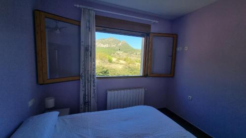 1 dormitorio con ventana y vistas a la montaña en Casa de la Santa, en Moratalla