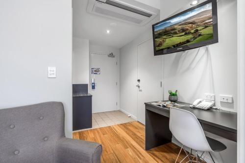 a room with a desk and a television on the wall at Essence Apartments Chermside in Brisbane