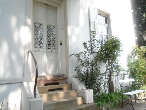 ein weißes Haus mit einer Treppe vor einer Tür in der Unterkunft Villa Martha in Badenweiler