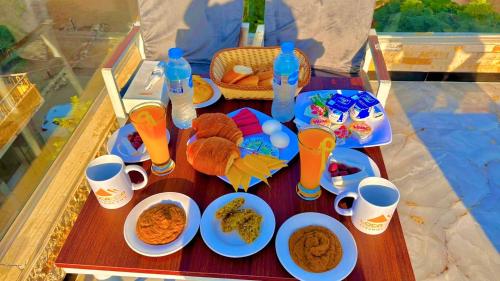 a table topped with plates of food and drinks at Locanda pyramids view in Cairo