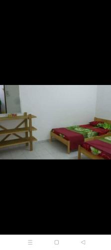 a room with two beds and a table at Muhibbah Homestay in Sungai Siput