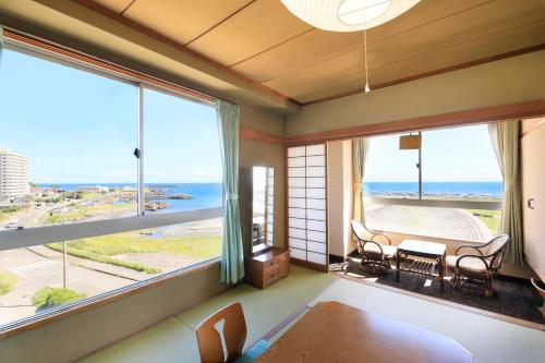 a living room with a view of the ocean at Boso Shirahama Umisato Hotel in Minamiboso
