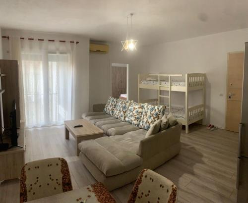 ein Wohnzimmer mit einem Sofa und einem Kinderbett in der Unterkunft I Love Tirana 3 in Tirana