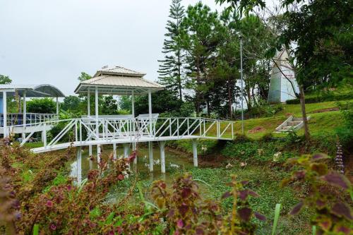a white bridge with a gazebo in a garden at เขาค้อออฟเลิฟ in Khao Kho