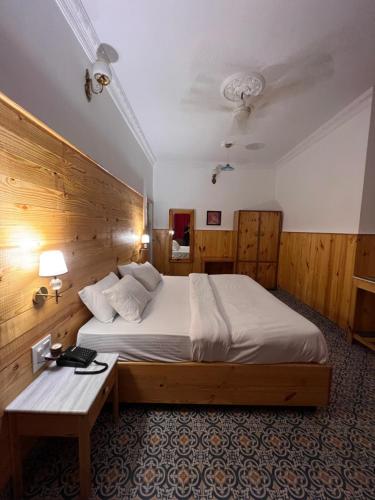 a bedroom with a large bed with a wooden wall at hotel saina inn in Dehradun