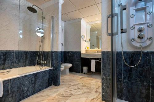 een badkamer met een douche, een bad en een toilet bij ALEGRIA Costa Ballena Aquafun in Costa Ballena