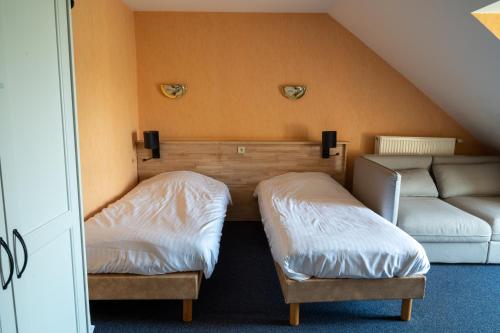 a room with two beds and a couch at Hotel Canteklaar in De Haan