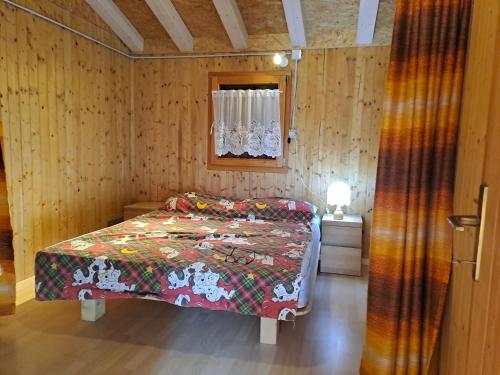 ein Schlafzimmer mit einem Bett in einem Holzzimmer in der Unterkunft La quiete di Tregiovo - CIPAT 22253-AT-34903 in Revò