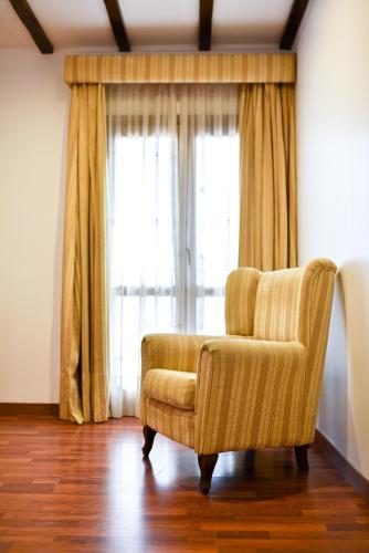 a chair in a room with a large window at ALEGRIA Bodega Real in El Puerto de Santa María