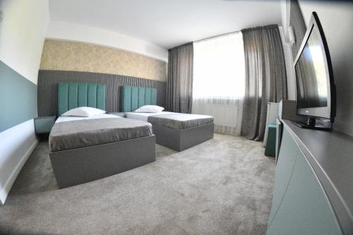 Habitación de hotel con 2 camas y TV en Hotel Parc en Craiova