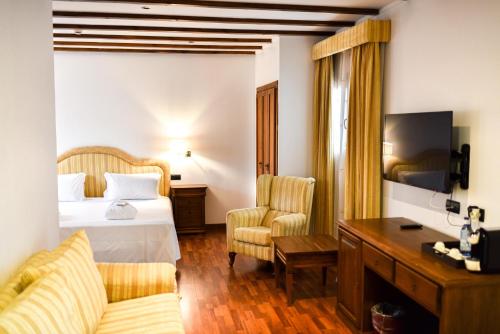 Cette chambre comprend un lit et un bureau. dans l'établissement ALEGRIA Bodega Real, à El Puerto de Santa María