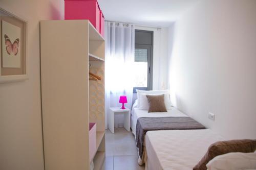 a small bedroom with two beds and a window at SANTA SUSANNA Chic! Apartments by ALEGRIA in Santa Susanna