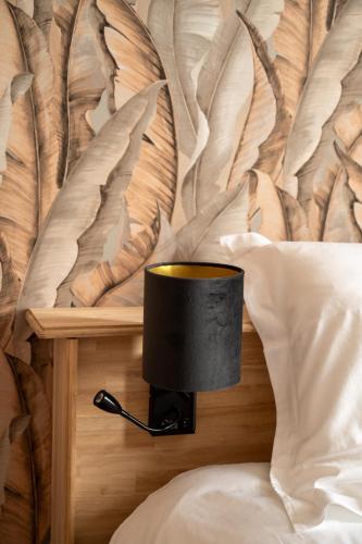 a black lamp on the side of a bed at Hotel Canteklaar in De Haan