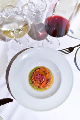 a white plate of food on a table with wine glasses at ALEGRIA Bodega Real in El Puerto de Santa María