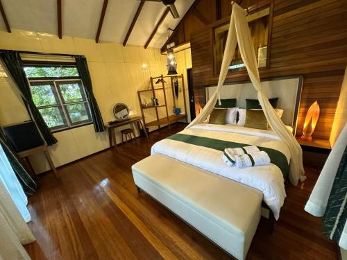 a bedroom with a large bed with a mosquito net at Sepilok Forest Edge Resort in Sepilok