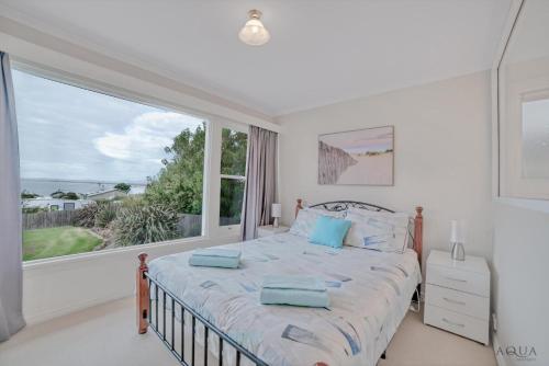 a bedroom with a bed and a large window at Panoramic Views on Walter in Bridport