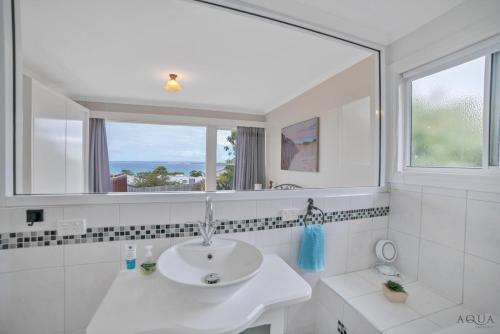 a white bathroom with a sink and a mirror at Panoramic Views on Walter in Bridport