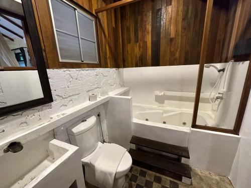 a bathroom with a toilet and a tub and a sink at Sepilok Forest Edge Resort in Sepilok