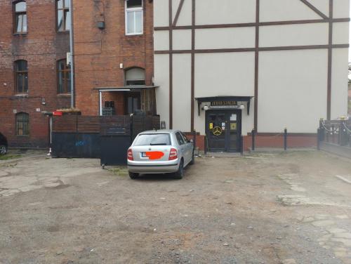 a car parked in a parking lot in front of a building at Hostel Rycerska in Wałbrzych