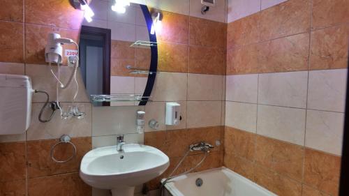 a bathroom with a sink and a toilet and a mirror at Hotel Parc in Craiova