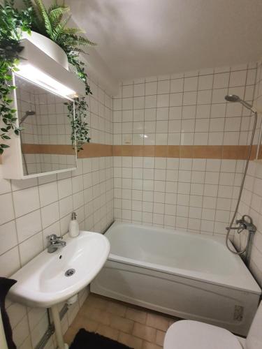 a bathroom with a tub and a sink and a bath tub at Close to the metro and the beach!!! with a view of the Scandinavian forest in Stockholm