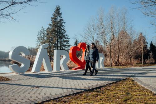 a couple walking in front of a sign with a heart at R31 Residence in Sárvár