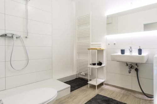 a white bathroom with a shower and a sink at Homefy Altstadt Apartment für 6 Personen, mit 2 Bädern und Balkon in Düsseldorf