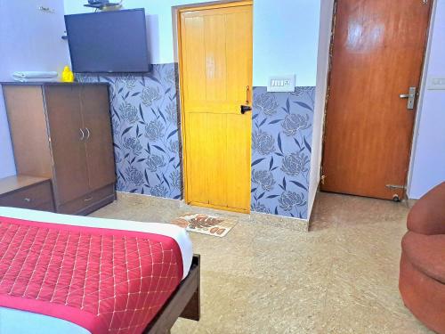 een kamer met een bed en een houten deur bij Atlas Inn Guest House in New Delhi