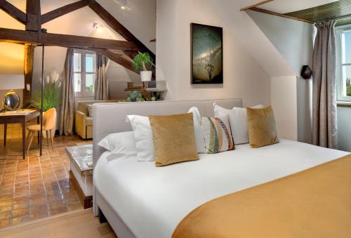 a bedroom with a large white bed with pillows at La Côte Saint Jacques in Joigny