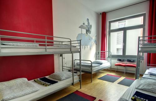 a room with two bunk beds and a red wall at Heart of Gold Hostel Berlin in Berlin