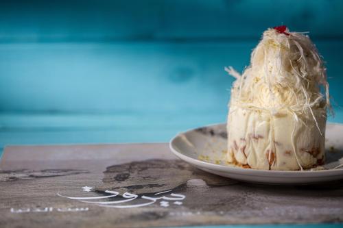 a piece of cake on a plate on a table at The Abdali Boulevard Hotel in Amman